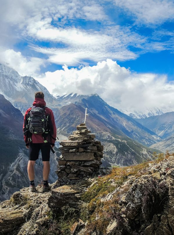 A person at the peak of a mountain looking at the himalayas